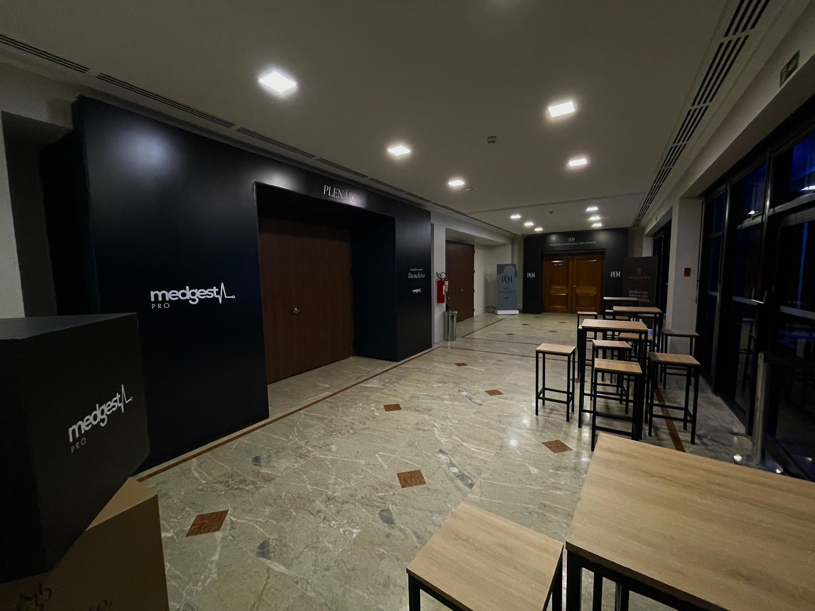 Corredor com parede cenográfica de acesso à sala plenária em evento corporativo