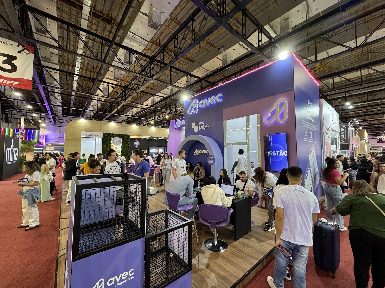 Vista geral de pavilhão de feira com stand cúbico em destaque