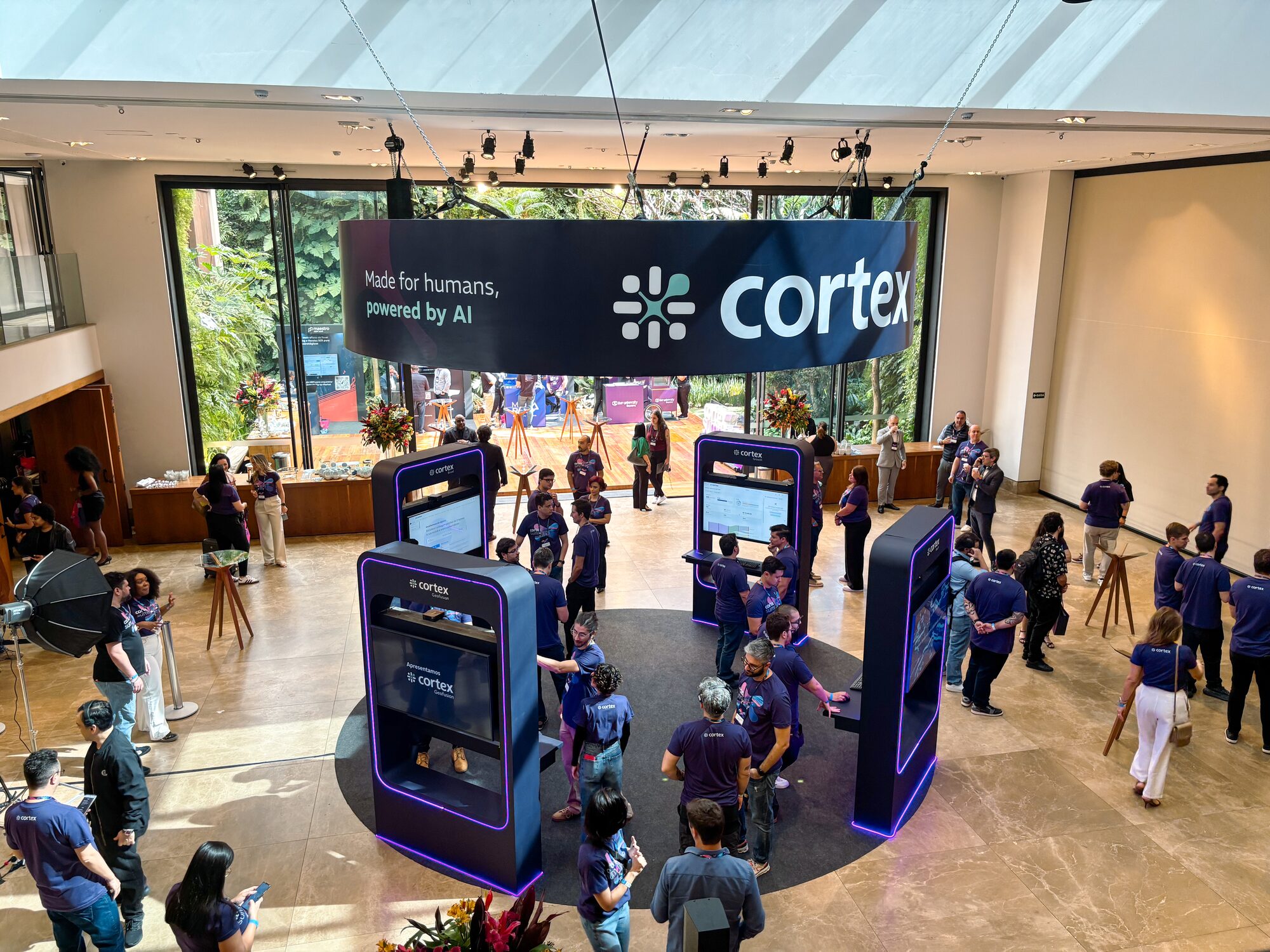 Testeira circular suspensa retroiluminada com totens de demonstração no Cortex Summit 2025, cenografia Atom Cenografia